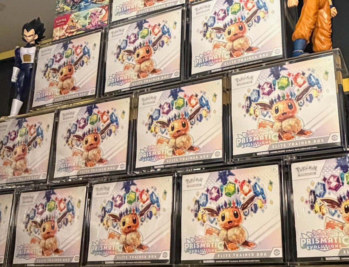 Prismatic Evolutions ETBs in TCG Protectors cases on a shelf