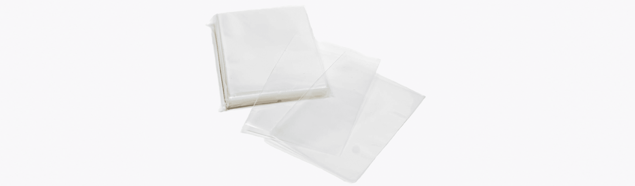 Three clear 50 micron standard card sleeves stacked on a white background for trading card game protection.