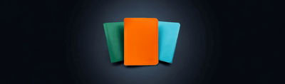 Colorful TCG Protectors premium zip binders in green, orange, and blue standing side-by-side against a dark background
