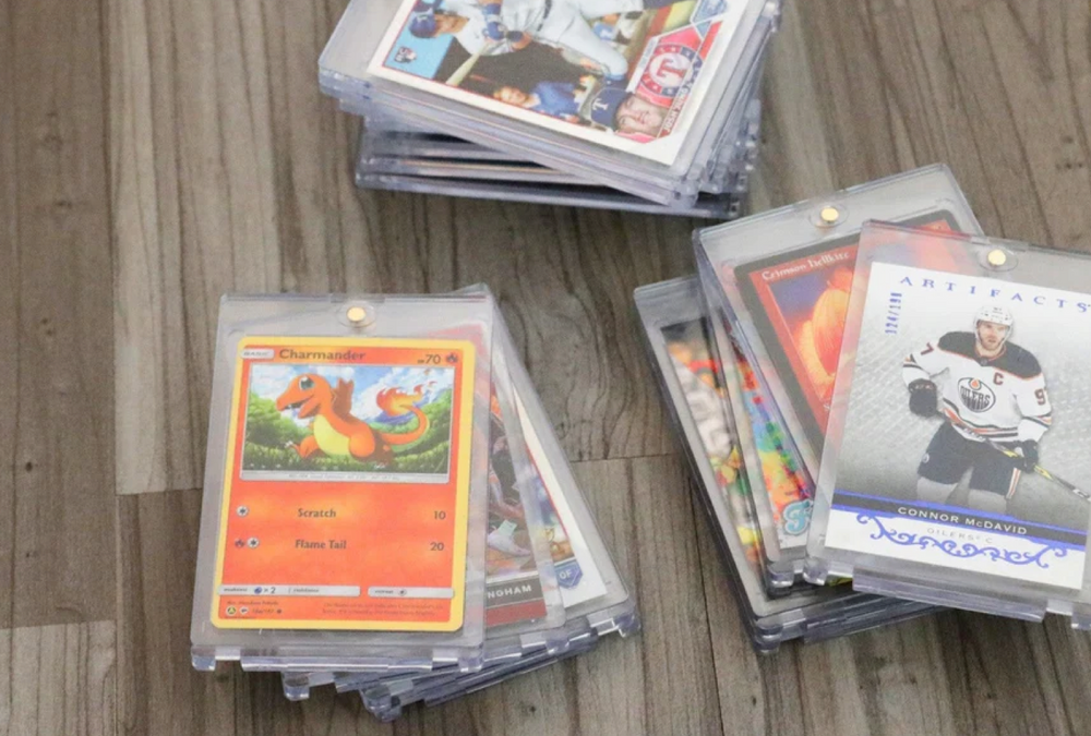 TCG Protectors crystal clear magnetic card holders displaying graded trading cards (Pokemon & Hockey) on a wood surface