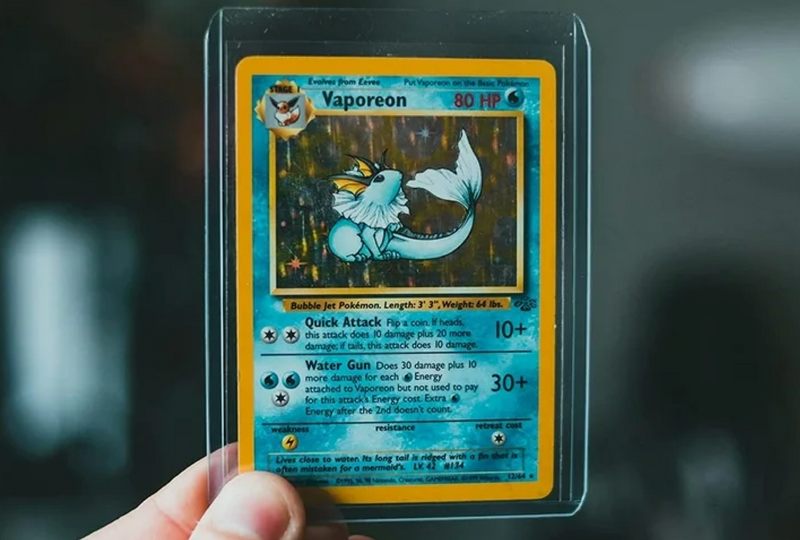 Clear plastic trading card toploader protecting a vintage Vaporeon Pokémon card