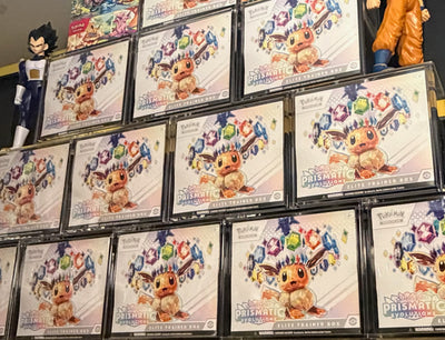 Prismatic evolutions in TCG Protectors cases displayed on a shelf.
