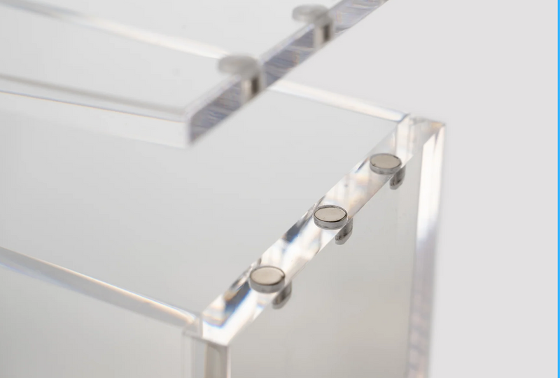 Close-up of premium N52 magnetic closure on a clear acrylic TCG display case